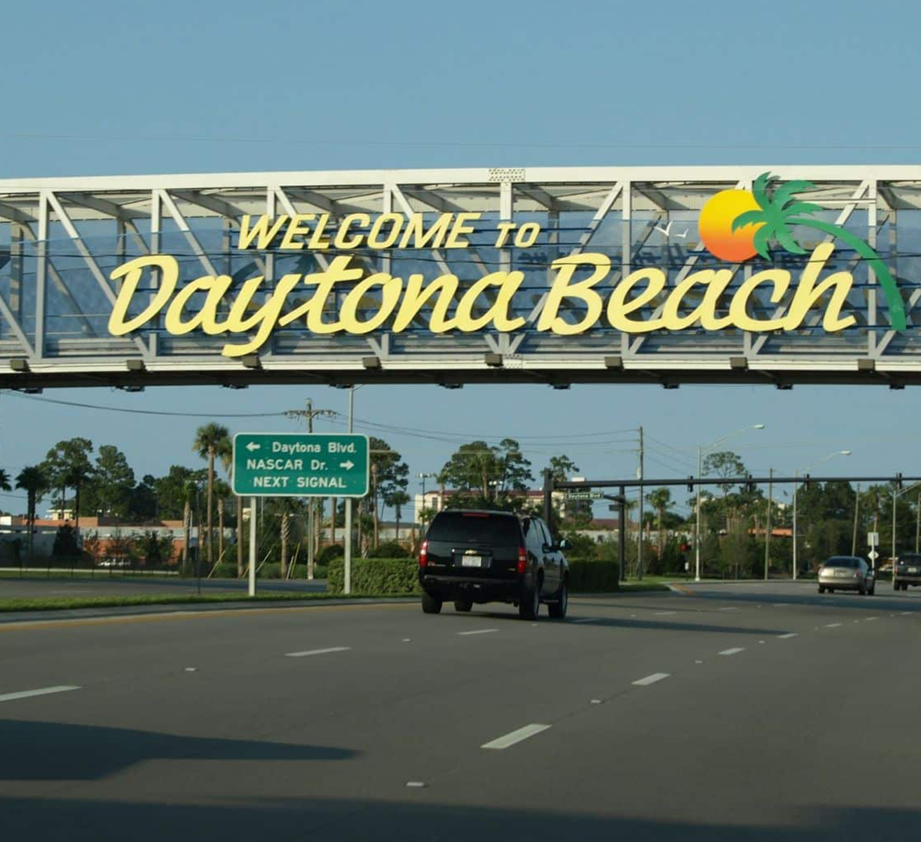 Photo of car driving under Welcome to Daytona Beach sign